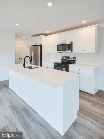 a kitchen with stainless steel appliances a microwave a sink and a refrigerator