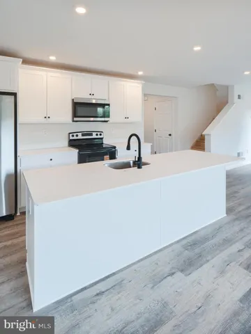a kitchen with a sink a stove and cabinets