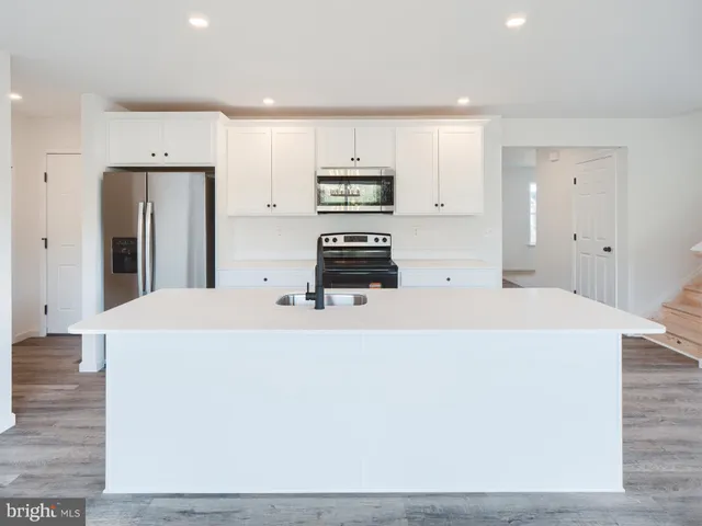 a large white kitchen with stainless steel appliances