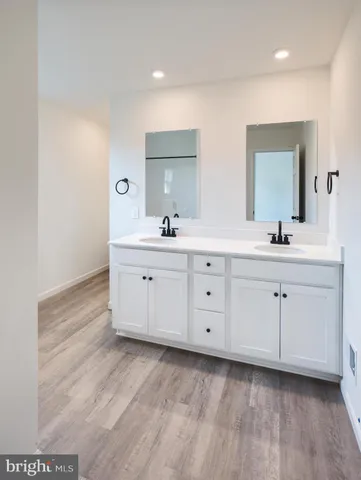 a spacious bathroom with a double vanity sink and mirror