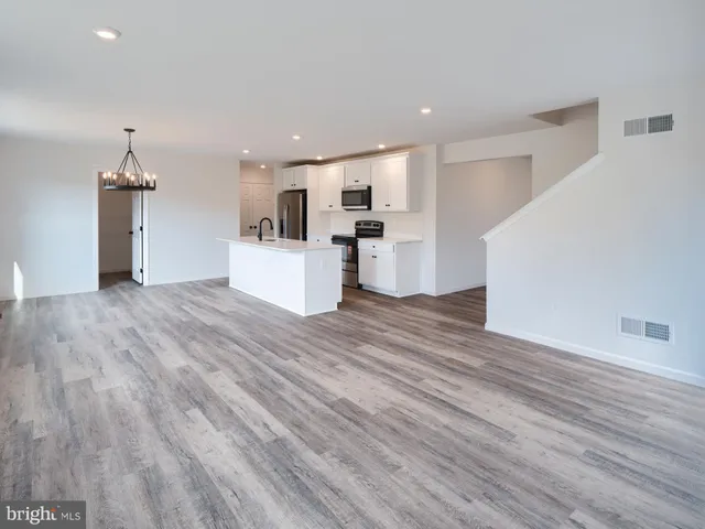 a view of kitchen with cabinets wooden floor and electronic appliances
