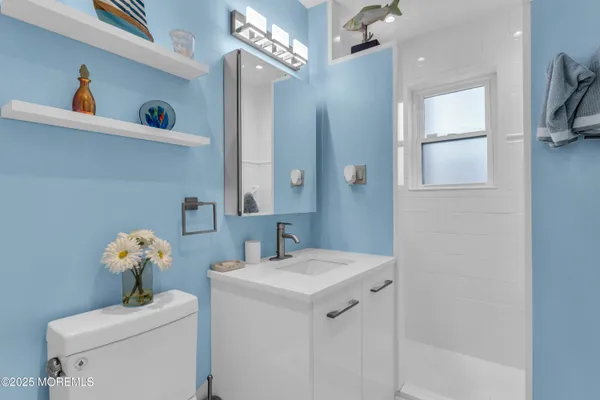 a bathroom with a sink a toilet and a mirror