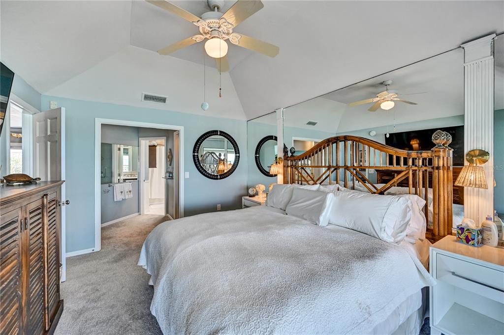 5854 Gasparilla Road, Unit M22 Boca Grande, FL 33921 - Photo 18 of 54 a bedroom with a large bed and a chandelier