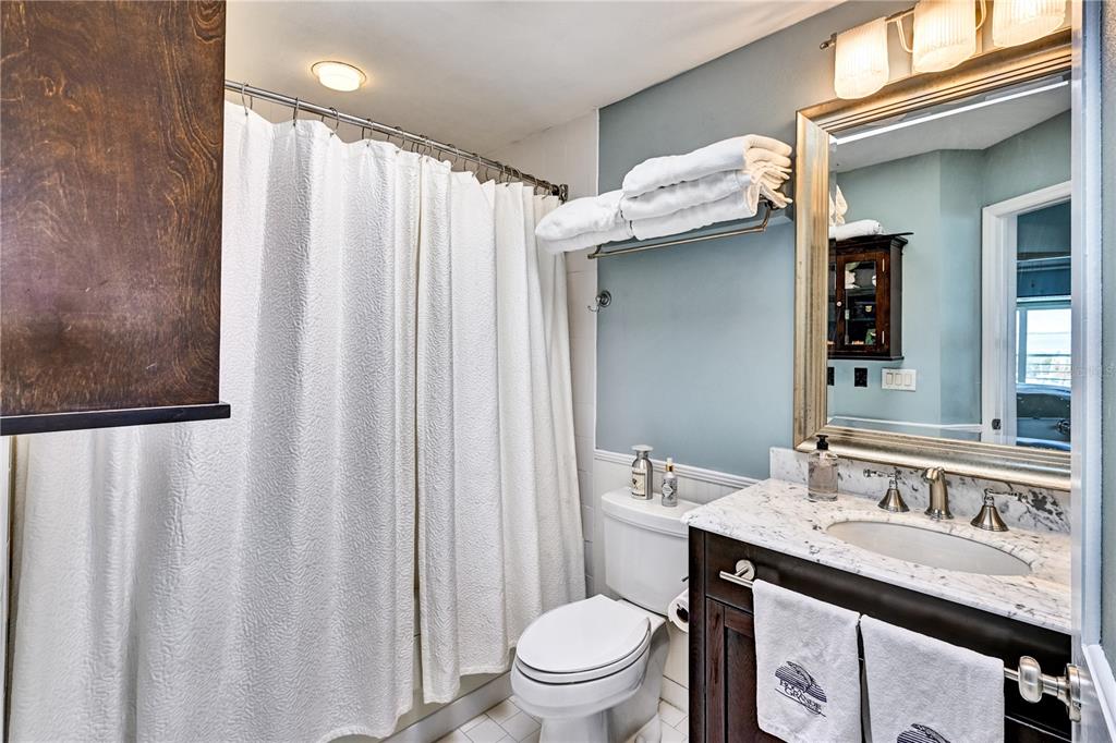 5854 Gasparilla Road, Unit M22 Boca Grande, FL 33921 - Photo 20 of 54 a bathroom with a granite countertop sink and a mirror