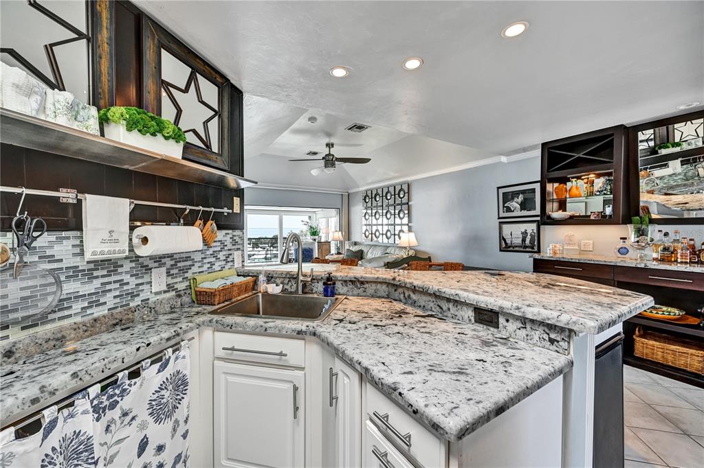 5854 Gasparilla Road, Unit M22 Boca Grande, FL 33921 - Photo 24 of 54 a kitchen with stainless steel appliances granite countertop a sink stove and cabinets