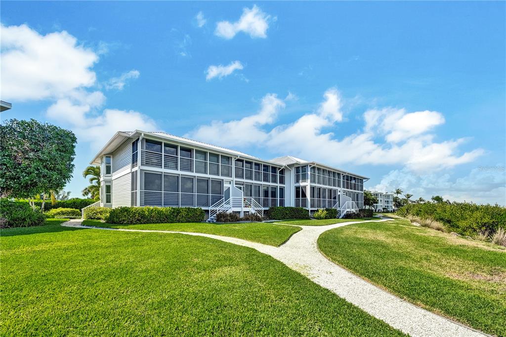 5854 Gasparilla Road, Unit M22 Boca Grande, FL 33921 - Photo 43 of 54 a view of a house with a big yard and large trees