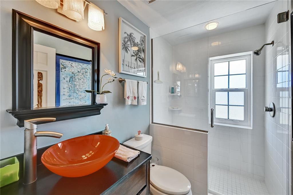 5854 Gasparilla Road, Unit M22 Boca Grande, FL 33921 - Photo 9 of 54 a blue bathroom with a toilet a sink and mirror