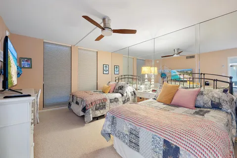 a bedroom with two beds and a flat screen tv