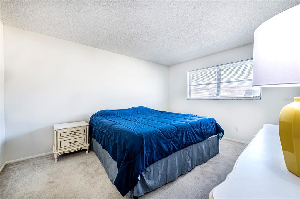 5197 Silent Loop, Unit 224 New Port Richey, FL 34652 - Photo 23 of 41 a bedroom with a bed and a couch with window