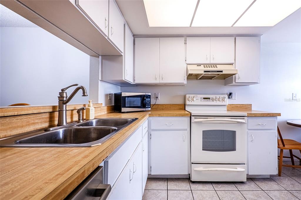 5197 Silent Loop, Unit 224 New Port Richey, FL 34652 - Photo 6 of 41 a kitchen with a sink a stove and cabinets