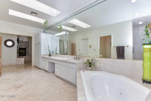 a spacious bathroom with a sink a mirror and a mirror