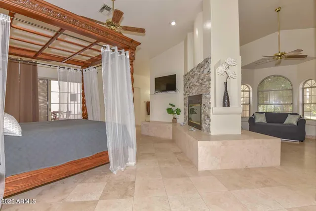 a spacious bedroom with a bed and a chandelier