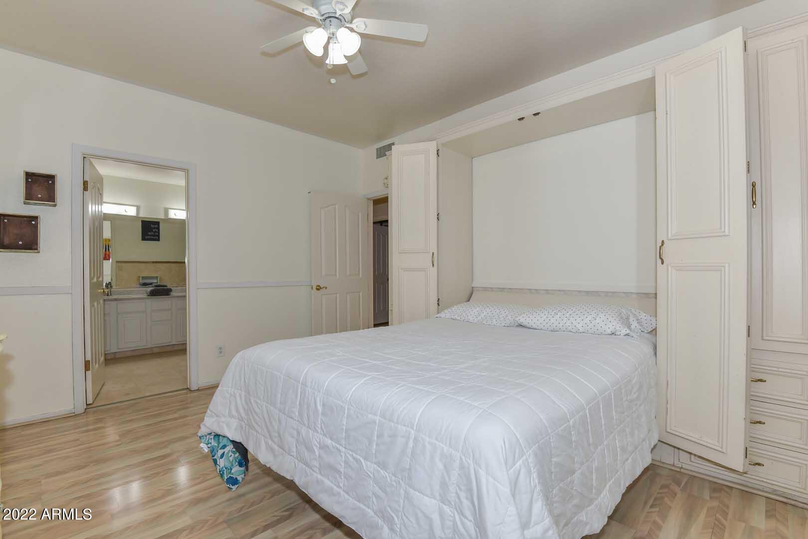 5237 North 106th Avenue Glendale, AZ 85307 - Photo 27 of 75 a spacious bedroom with a bed and a chandelier