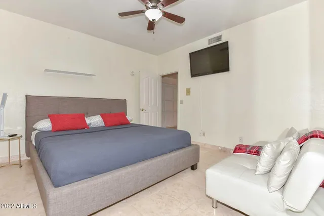 a spacious bedroom with a bed and a large window