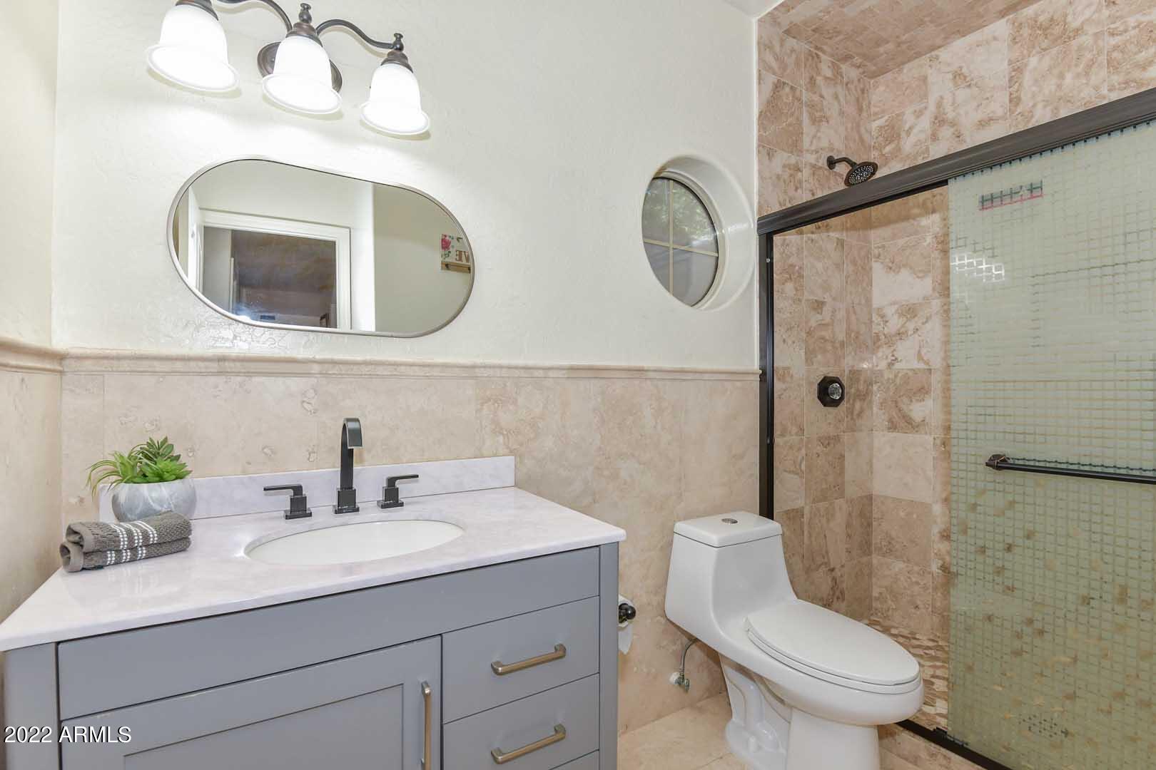 5237 North 106th Avenue Glendale, AZ 85307 - Photo 32 of 75 a bathroom with a toilet a sink and mirror