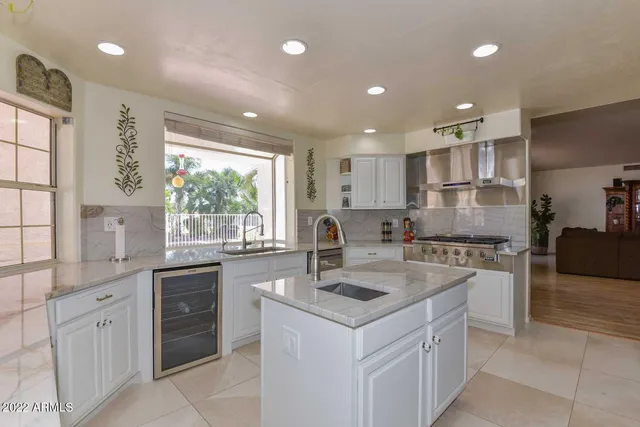 a kitchen with white cabinets and sink