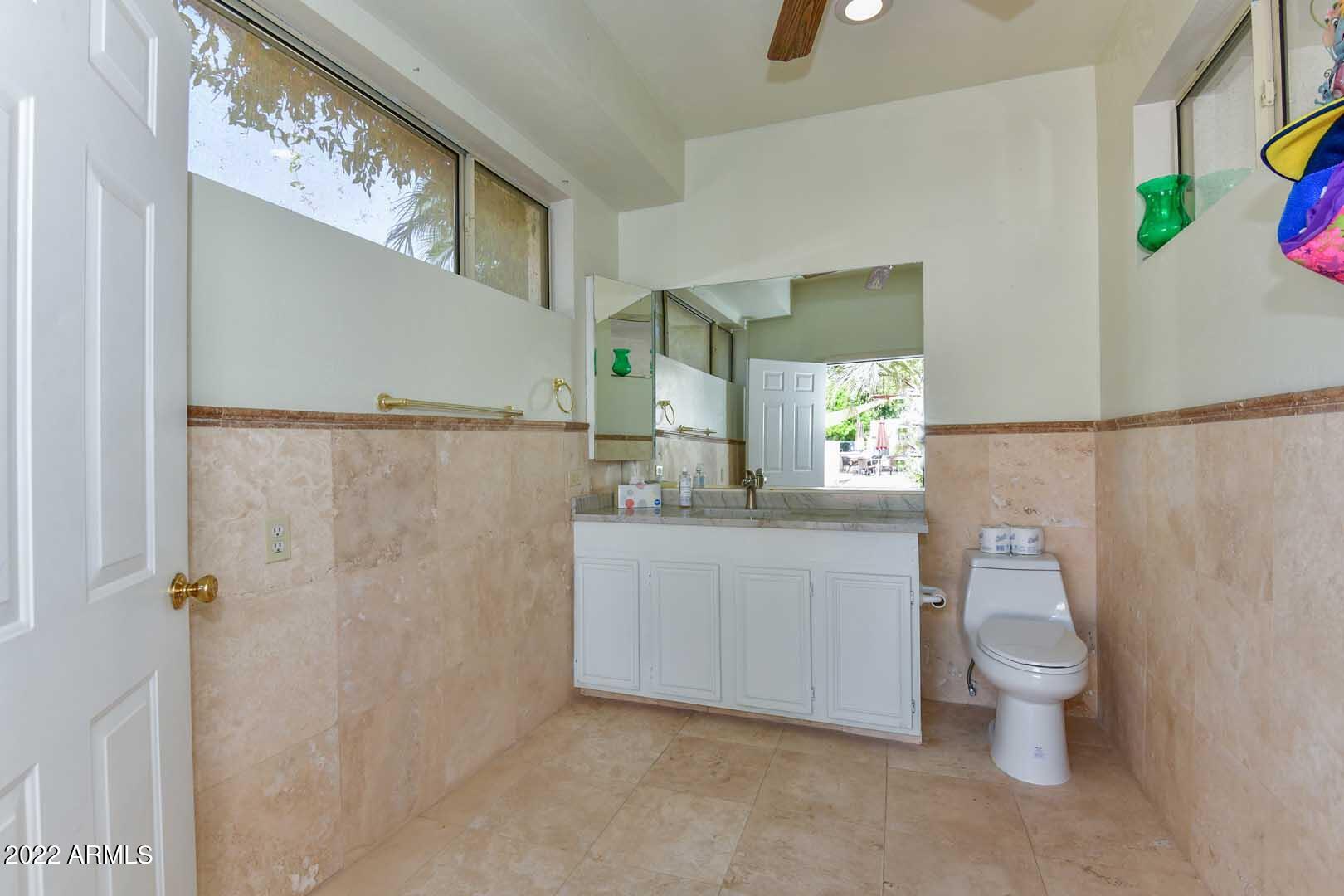 5237 North 106th Avenue Glendale, AZ 85307 - Photo 68 of 75 a bathroom with a sink a toilet a mirror a vanity and shower