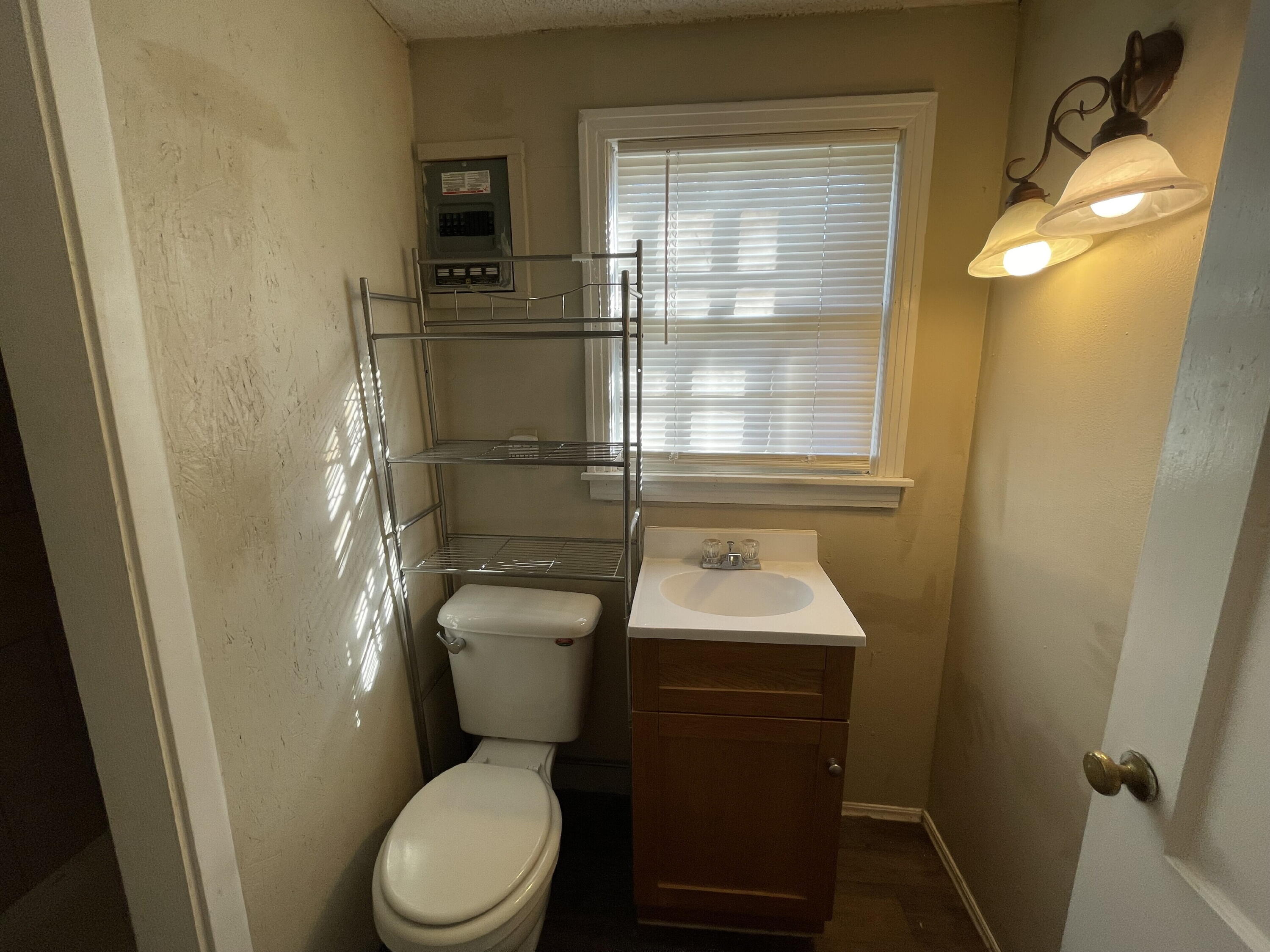 2520 27th Street, Unit REAR HOUSE Lubbock, TX 79410 - Photo 11 of 21 a bathroom with a toilet sink and mirror
