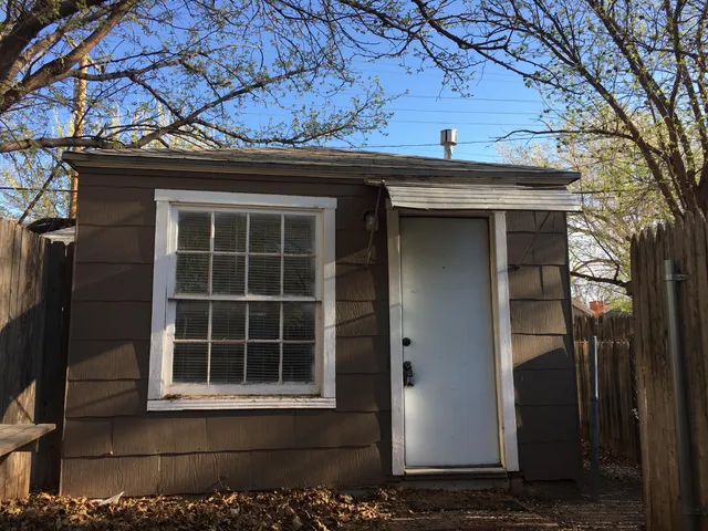 a view of a house with a door and wooden walls