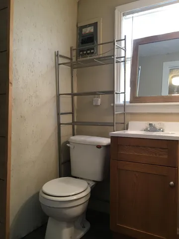 a bathroom with a toilet a sink and mirror