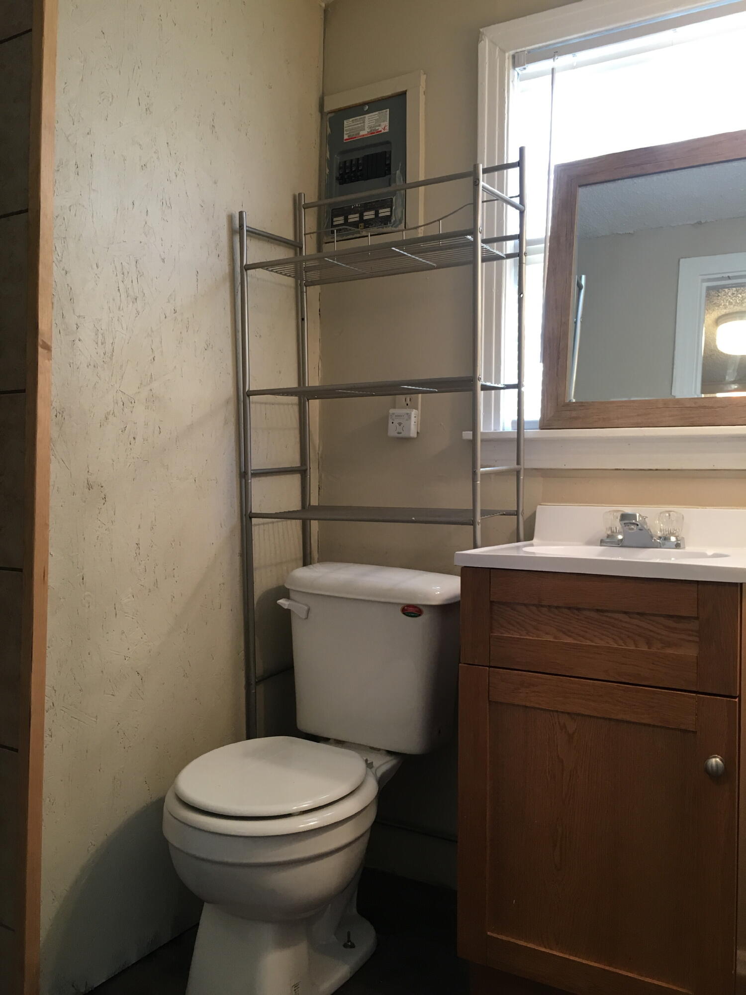 2520 27th Street, Unit REAR HOUSE Lubbock, TX 79410 - Photo 19 of 21 a bathroom with a toilet a sink and mirror