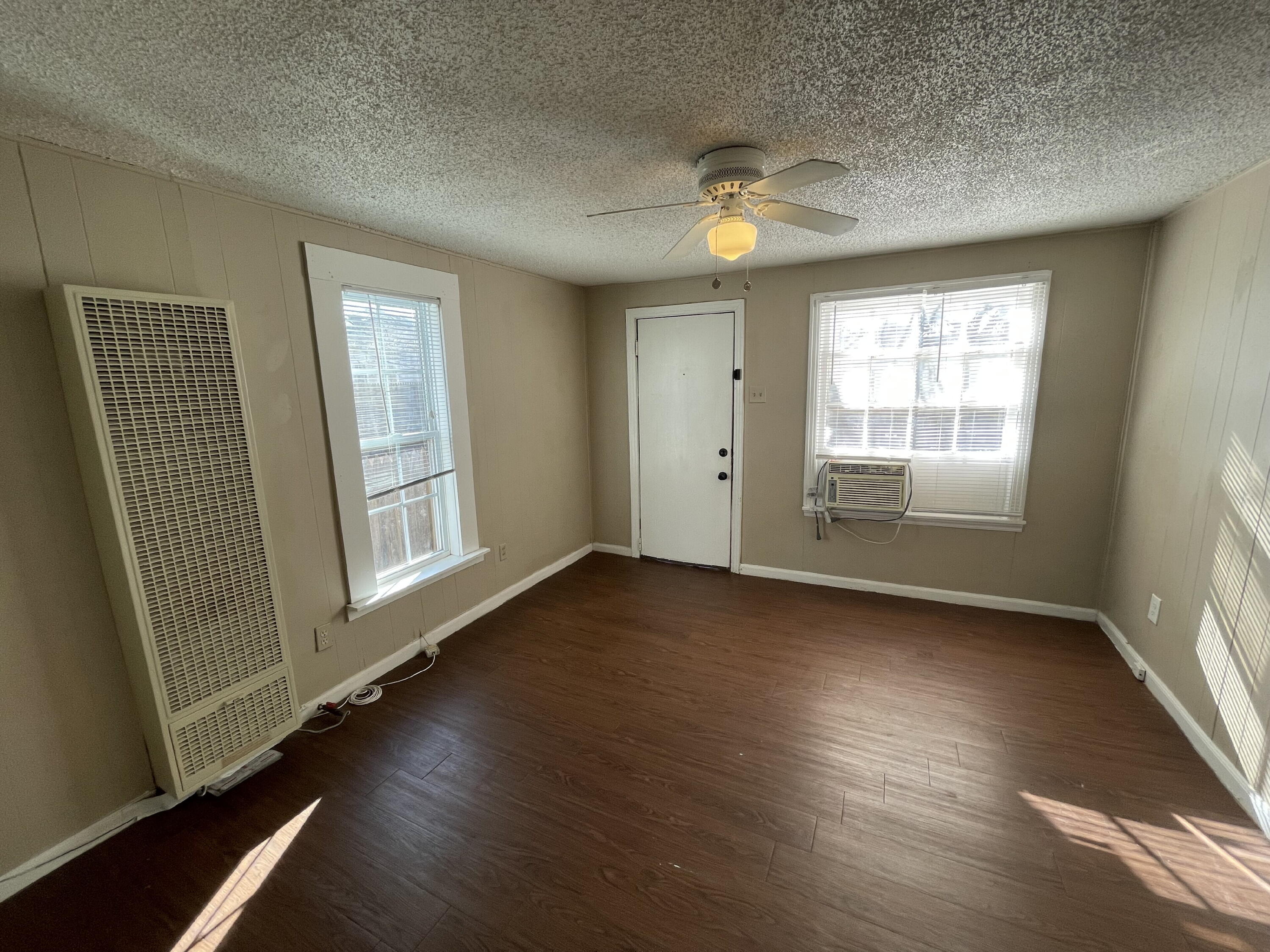 2520 27th Street, Unit REAR HOUSE Lubbock, TX 79410 - Photo 6 of 21 an empty room with wooden floor and windows