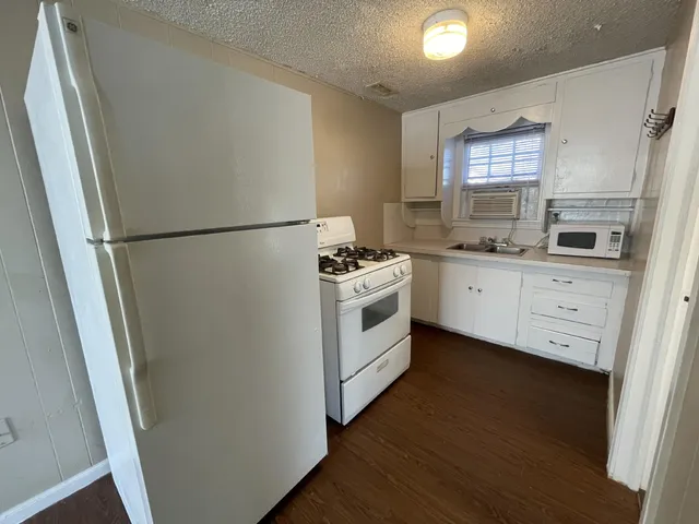 a kitchen with white cabinets and white appliances