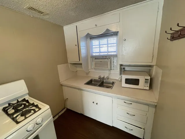 a kitchen with a stove and white cabinets