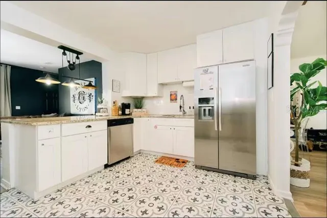 a kitchen with granite countertop a refrigerator and a stove top oven
