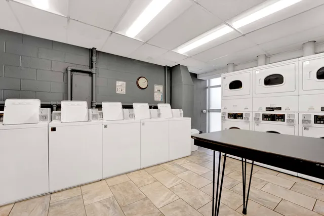 a room with table chairs and white appliances