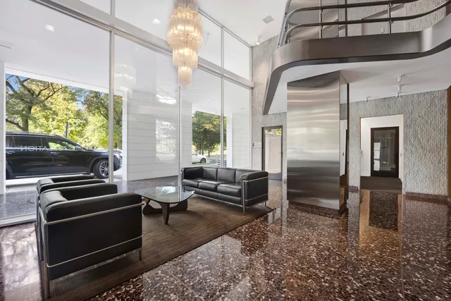 a living room with furniture a flat screen tv and floor to ceiling window