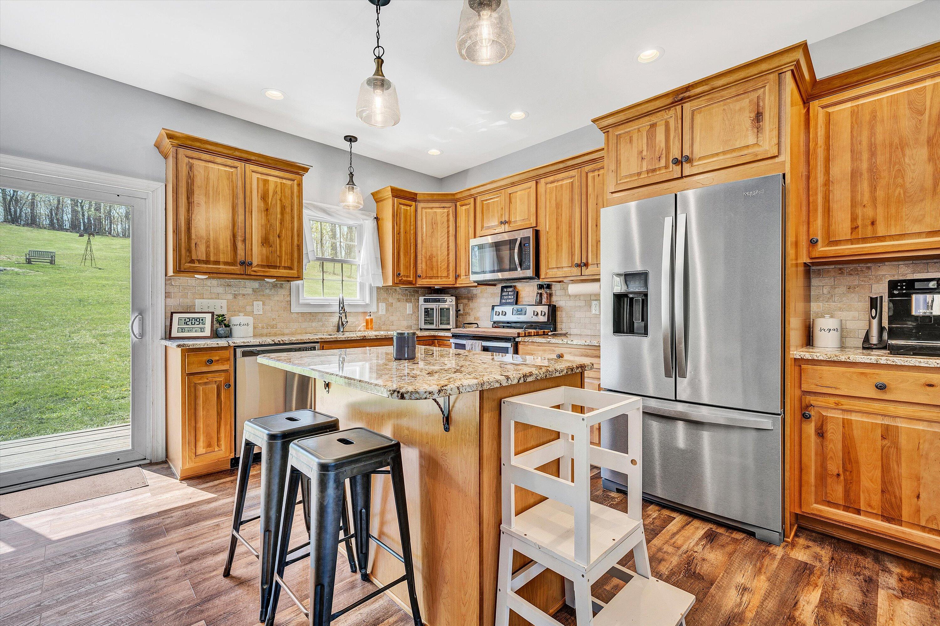 8350 Newport Road Catawba, VA 24070 - Photo 14 of 75 a kitchen with stainless steel appliances granite countertop a refrigerator a stove a sink dishwasher and a microwave oven with wooden floor