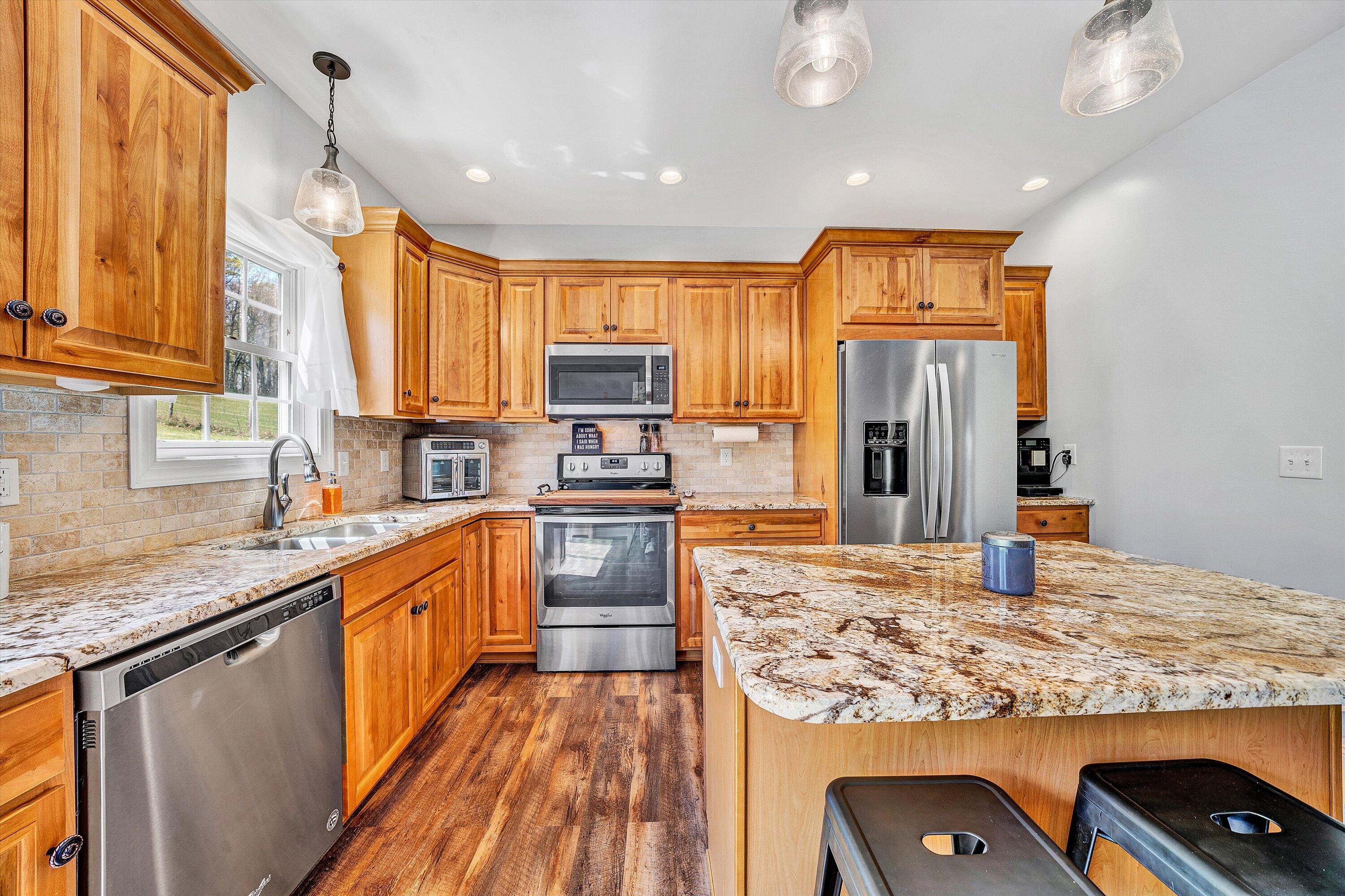 8350 Newport Road Catawba, VA 24070 - Photo 15 of 75 a kitchen with kitchen island granite countertop a sink appliances cabinets and furniture