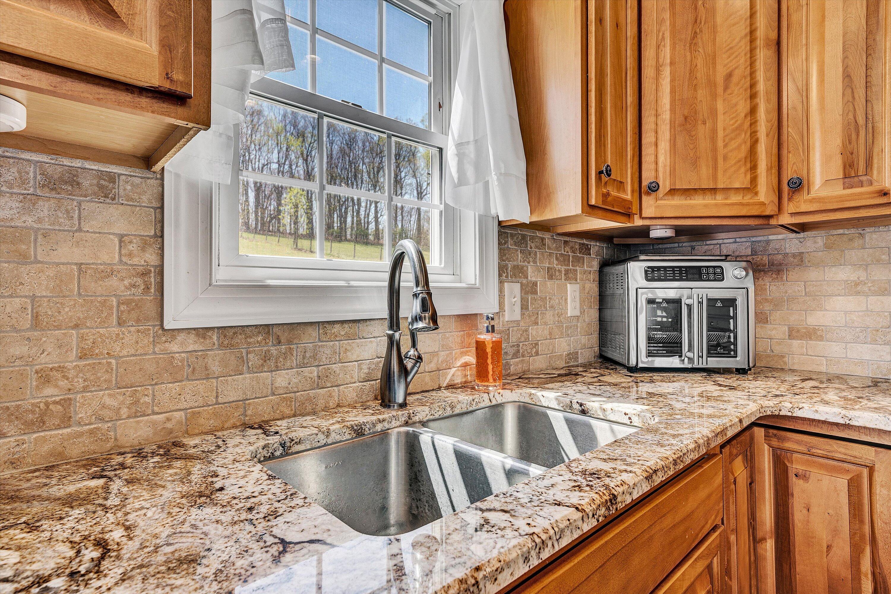8350 Newport Road Catawba, VA 24070 - Photo 17 of 75 a kitchen with stainless steel appliances granite countertop a sink and a wooden cabinets