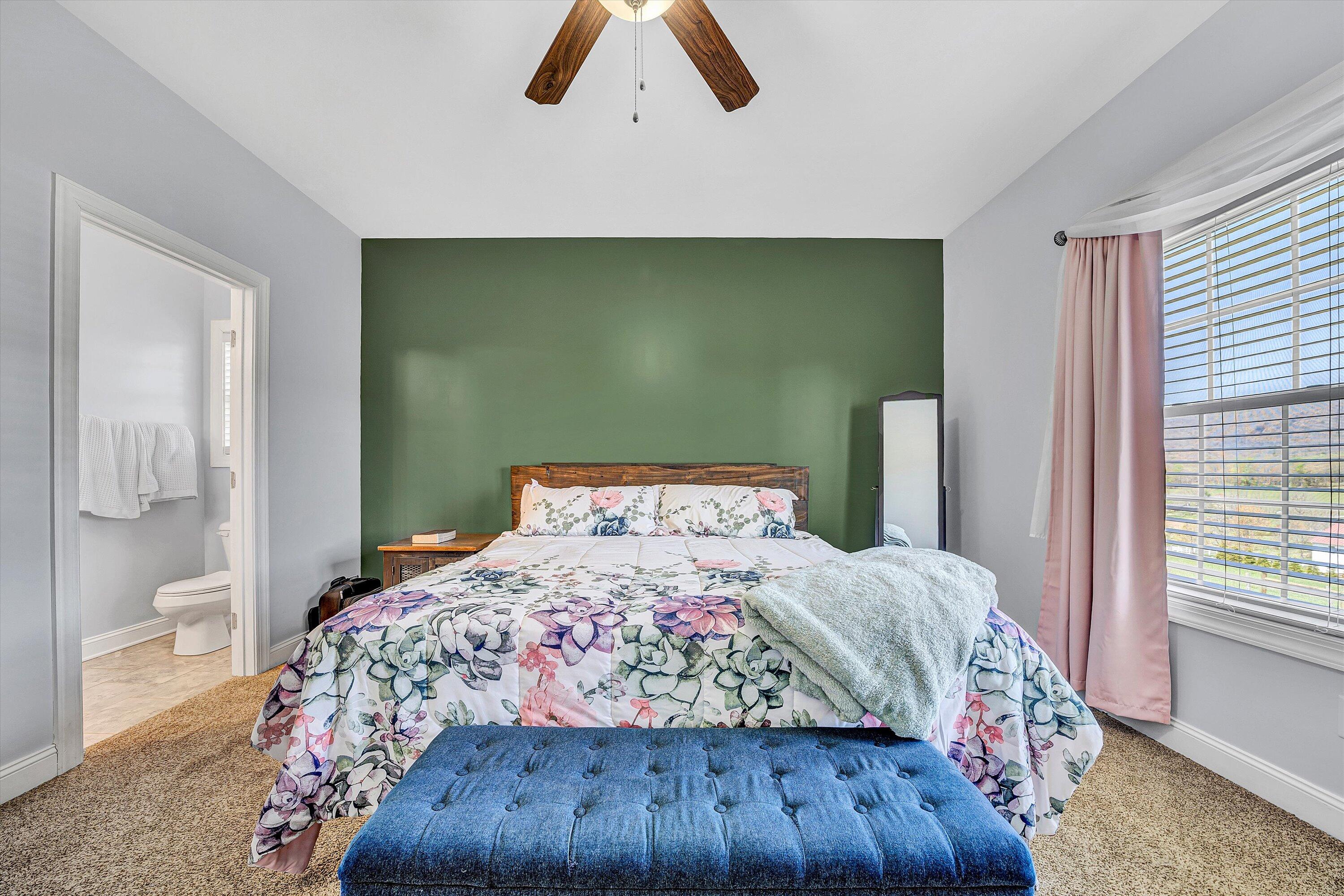 8350 Newport Road Catawba, VA 24070 - Photo 20 of 75 a bedroom with a large bed and a chandelier