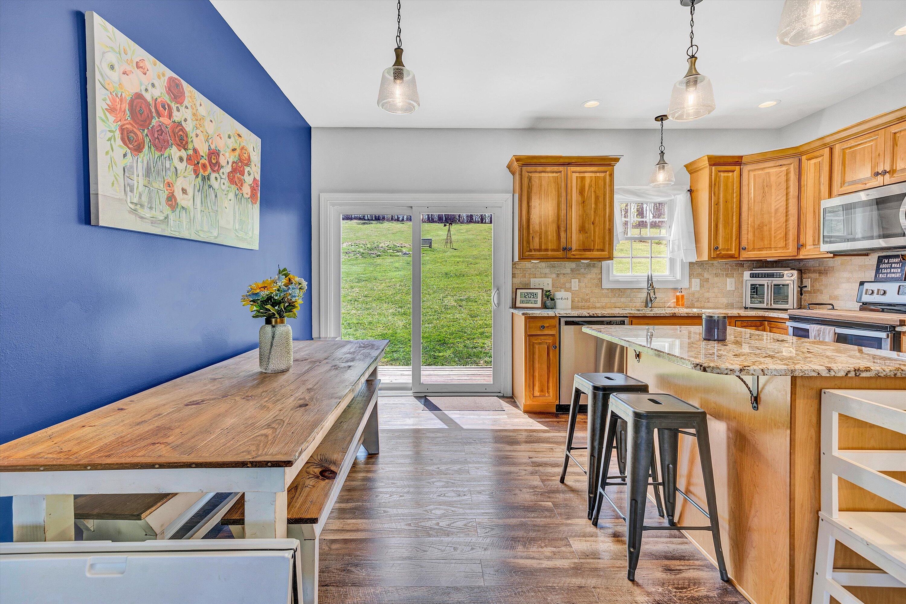 8350 Newport Road Catawba, VA 24070 - Photo 10 of 75 a kitchen with stainless steel appliances granite countertop a stove a refrigerator a oven with a dining table and chairs