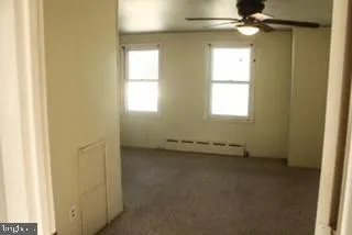an empty room with a window and a fan