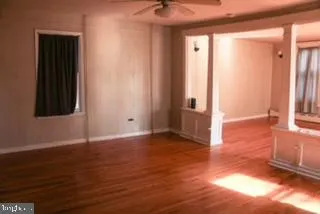an empty room with wooden floor and a window