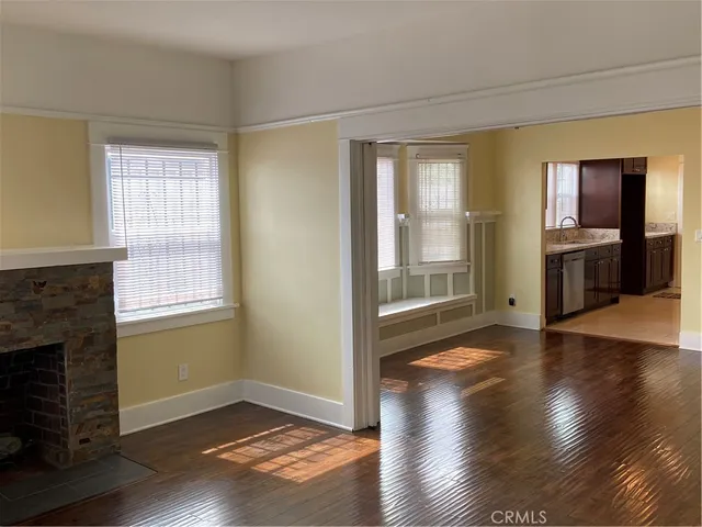 a view of empty room with wooden floor and fireplace