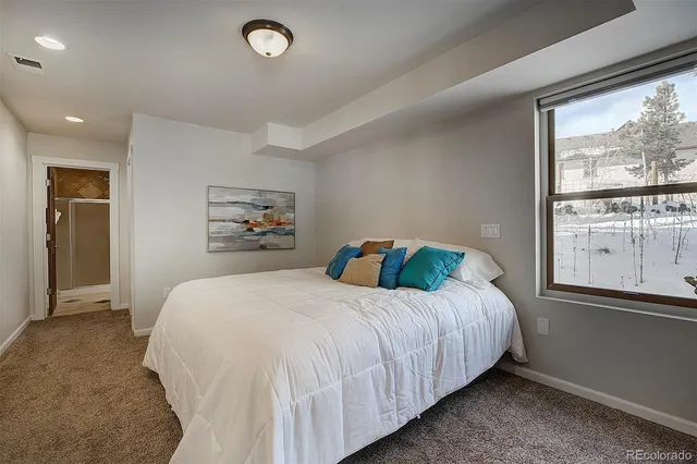 a bedroom with a bed and a large window