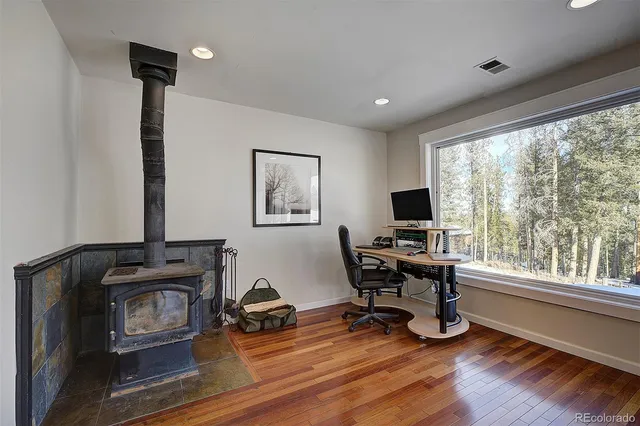 a view of a workspace with furniture and a window