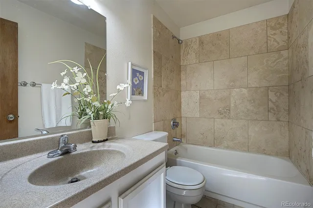 a bathroom with a granite countertop sink toilet and shower