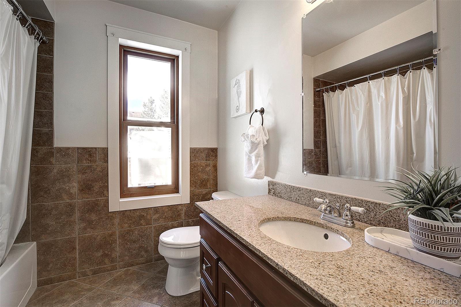 27987 Pine Grove Trail Conifer, CO 80433 - Photo 26 of 37 a bathroom with a granite countertop sink toilet and mirror
