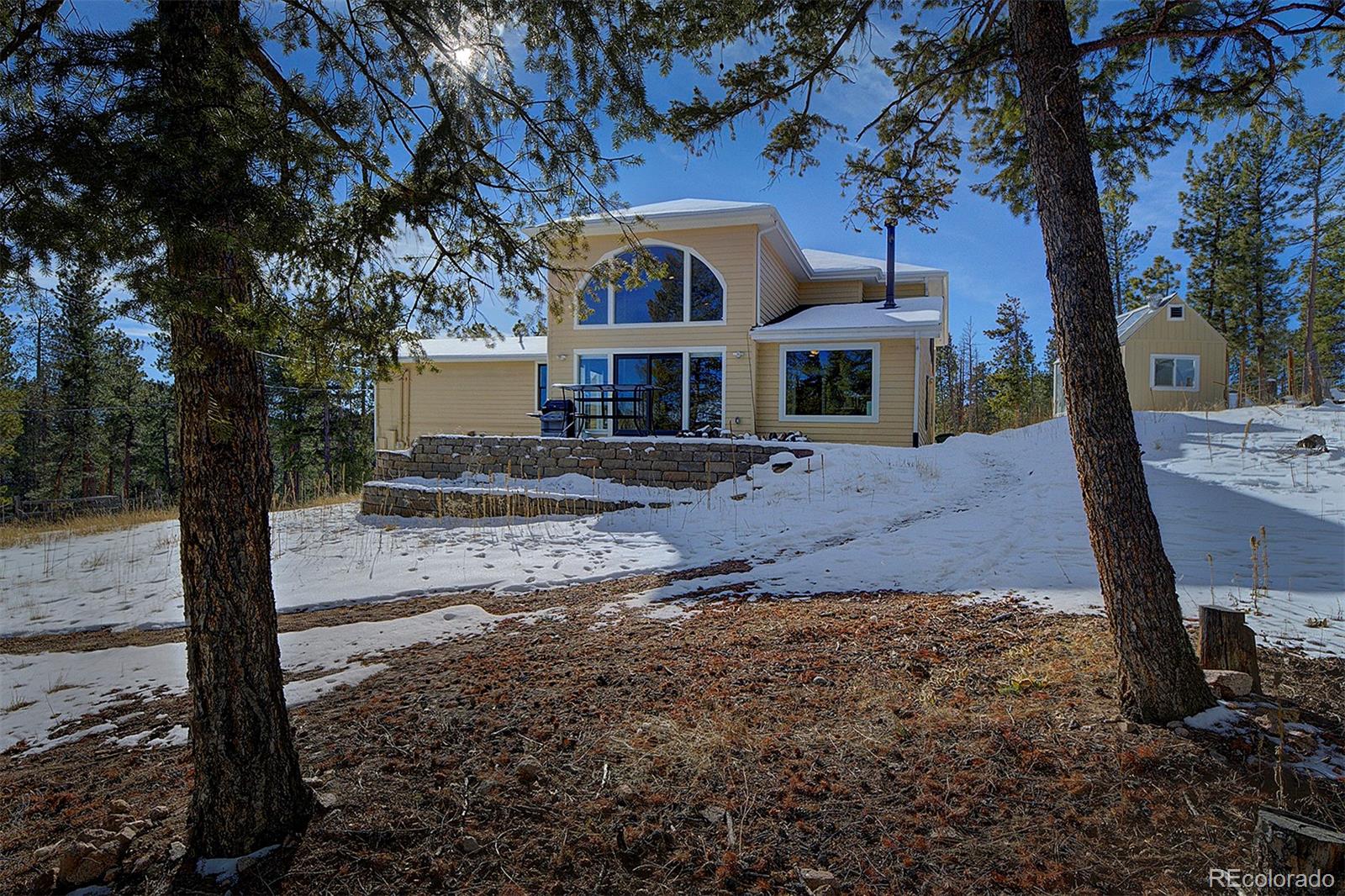 27987 Pine Grove Trail Conifer, CO 80433 - Photo 3 of 37 a front view of a house with a yard covered with trees