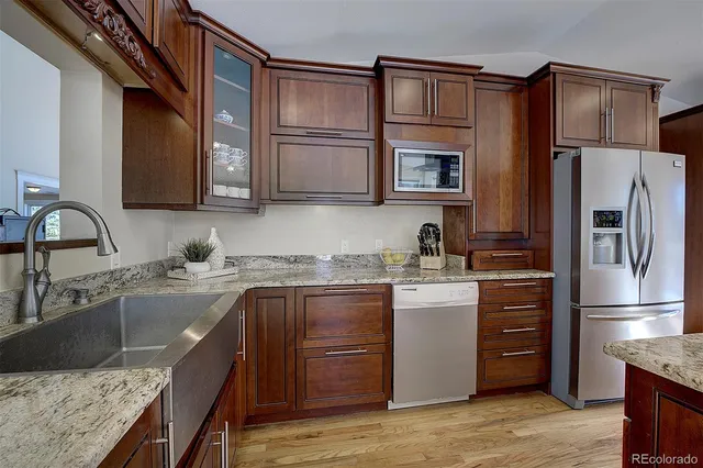 a kitchen with a refrigerator sink and cabinets