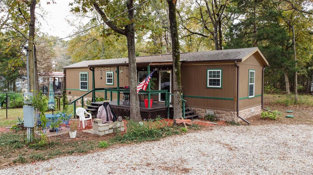 a view of a house with a yard and large tree