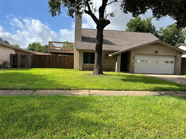 a view of a big house with a big yard and large trees