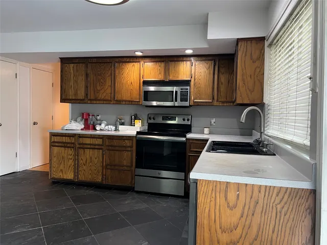 a kitchen with stainless steel appliances a stove a sink and a refrigerator