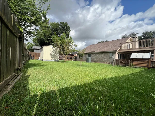 a view of a house with backyard and a tree