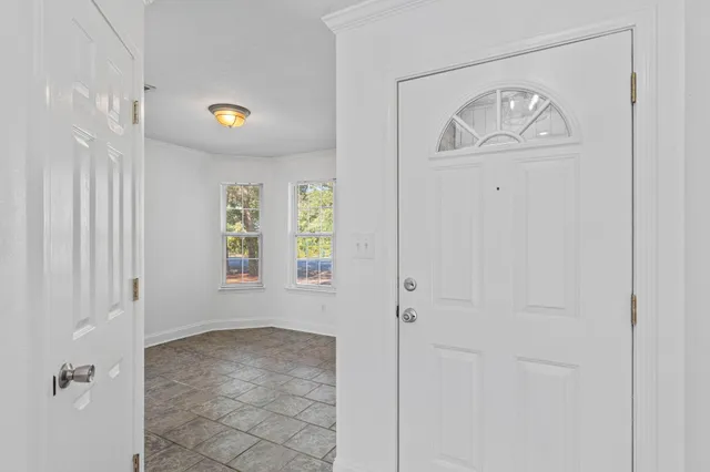 a kitchen with stainless steel appliances granite countertop a sink a stove and a granite counter tops with white cabinets next to a window